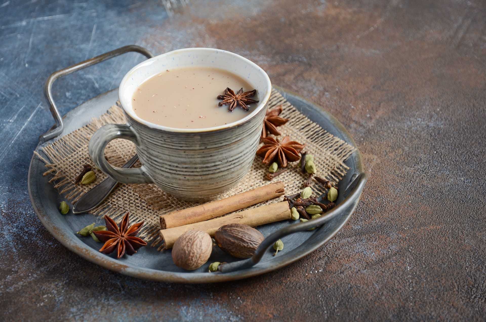 Indian masala chai tea. Spiced tea with milk on dark rusty background.